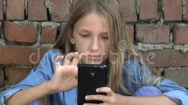孩子使用智能手机，孩子在智能手机上聊天，<strong>青少年</strong>女孩在公园户外<strong>上网</strong>